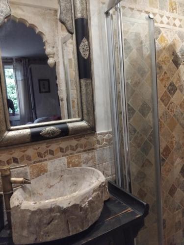 une salle de bain avec un lavabo en pierre et un miroir dans l'établissement Lou Masou, à Flayosc