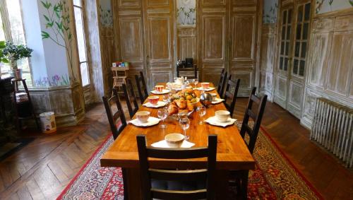 a long wooden table in a room with chairs at Le Manoir in Tarare