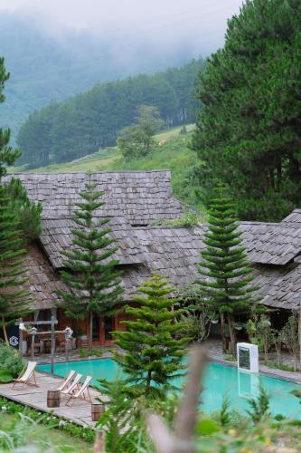 a house with a swimming pool in front of it at The Nordic Village - Evergreen Retreat in Mộc Châu