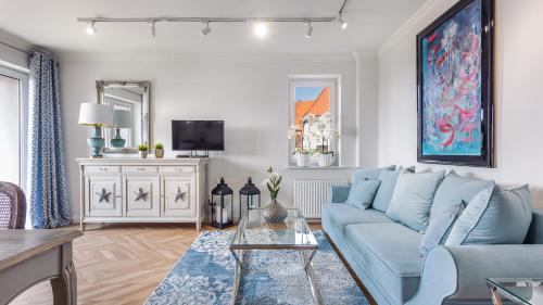 a living room with a blue couch and a tv at Hel Centrum, Sun & Snow in Hel