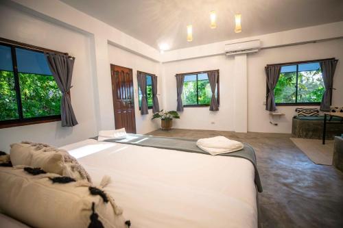 a bedroom with a large bed in a room with windows at Watergate Villa- Siargao Island in General Luna