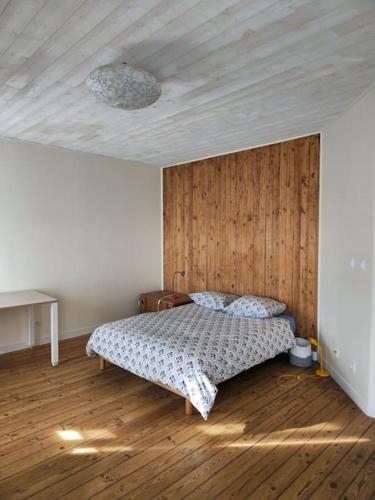 une chambre avec un lit et un mur en bois dans l'établissement Ty Béné - Maison de charme - 1-7 personnes, à Riec-sur-Bélon