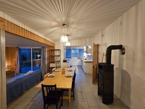 - une cuisine et une salle à manger avec une table et un poêle à bois dans l'établissement Ty Béné - Maison de charme - 1-7 personnes, à Riec-sur-Bélon