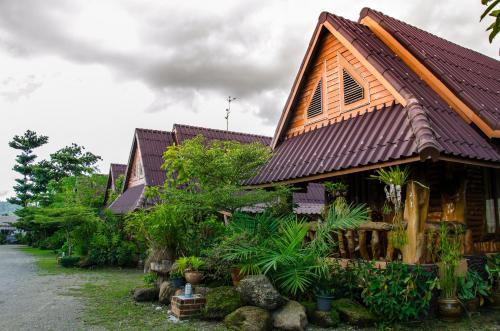 a house with a wooden roof and some plants at Daranee Resort in Ranong