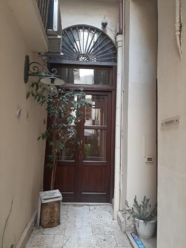 a wooden door with a plant in front of it at Locanda Scirocco in Castellammare del Golfo