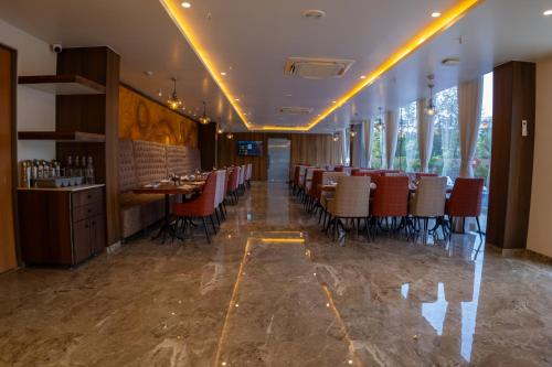 a dining room with tables and chairs in a restaurant at Pride Elite, Daman in Daman