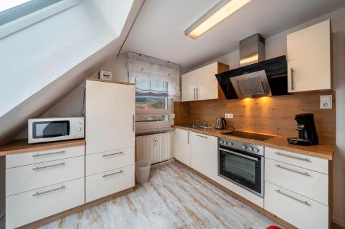 a kitchen with white cabinets and a microwave at Ferienwohnung Burgblick in Hausach