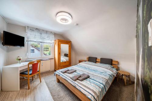 a bedroom with a bed and a desk and a computer at Ferienwohnung Burgblick in Hausach