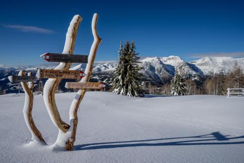 a sign in the snow with mountains in the background at Hotel Panoramic Lotsch in Sarntal