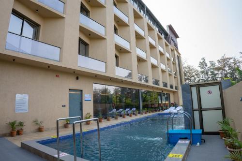 a swimming pool in front of a building at Pride Elite, Daman in Daman