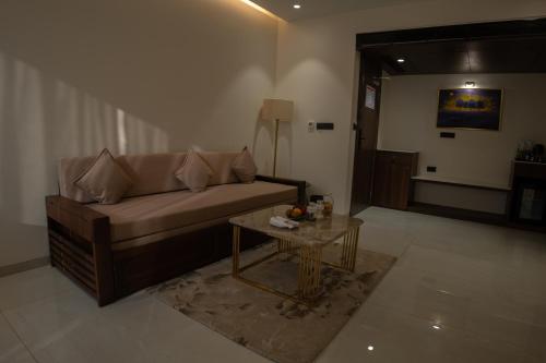 a living room with a couch and a table at Pride Elite, Daman in Daman
