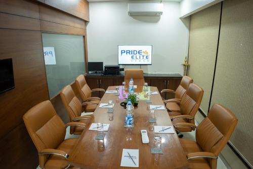 a conference room with a long wooden table and chairs at Pride Elite, Daman in Daman