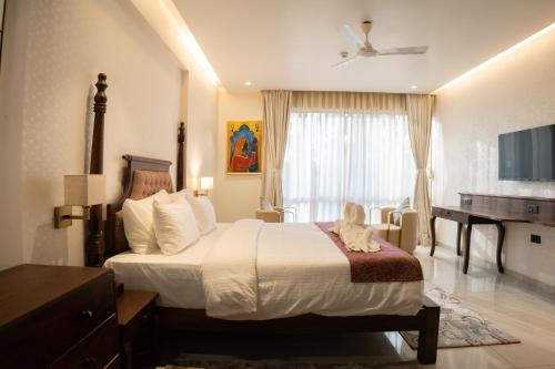 a hotel room with a large bed and a desk at Pride Elite, Daman in Daman