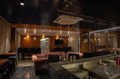 a restaurant with couches and a bar in a room at Pride Elite, Daman in Daman