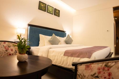 a hotel room with a bed and a table at Pride Elite, Daman in Daman