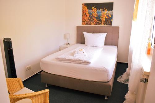 a small bedroom with a bed with white sheets at Hike Inn Hotels by Emmerich in Winningen
