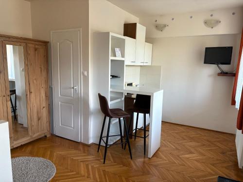 a small kitchen with a desk and stools in a room at RT Home Vendégház in Szombathely