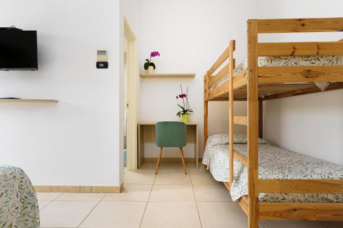 a bedroom with a bunk bed and a desk with a television at Delle Rose Horses Club in Torre Vado