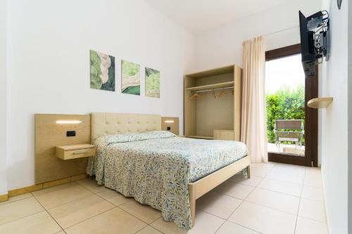 a bedroom with a bed and a sliding glass door at Delle Rose Horses Club in Torre Vado