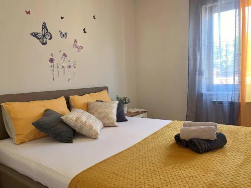 sypialnia z łóżkiem z motylami na ścianie w obiekcie Apartment Rozi w mieście Šilo