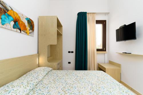 a small bedroom with a bed and a television at Delle Rose Horses Club in Torre Vado