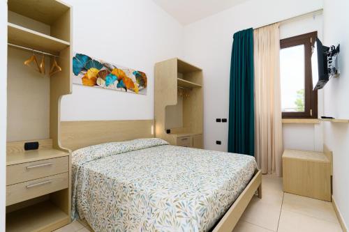 a small bedroom with a bed and a window at Delle Rose Horses Club in Torre Vado