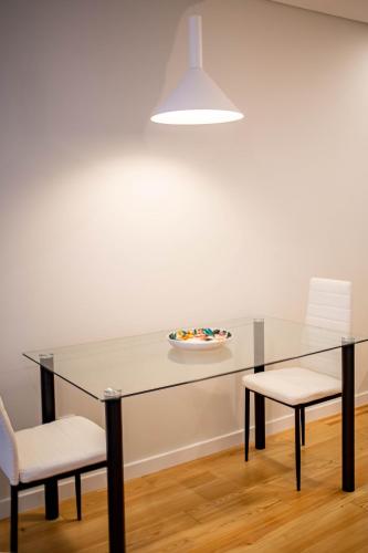 a dining room with a glass table and two chairs at ISABELLA STUDIOS FUNCHAL in Funchal