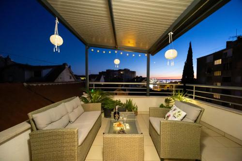 a patio with a couch and chairs on a balcony at Apartment Dome in Split