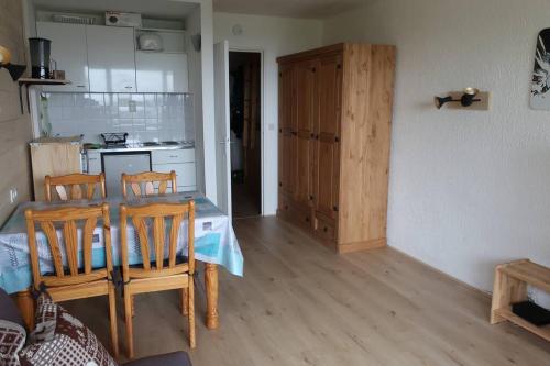 une cuisine avec une table et des chaises dans une pièce dans l'établissement SLA107 - Apt lumineux 4pers vue lac Tignes, à Tignes