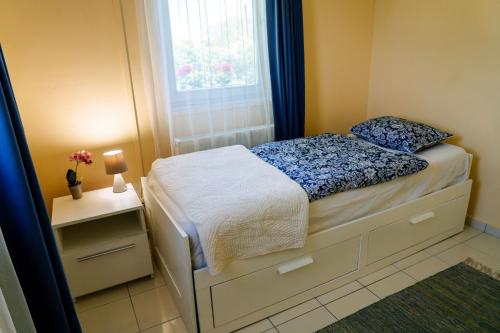 a small bedroom with a bed and a window at Kamala Kutir in Somogyvámos