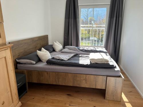 una cama en una habitación con ventana en Landhaus Heck, en Pfronten