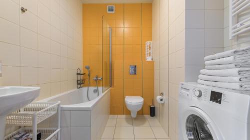 a bathroom with a toilet and a sink and a washing machine at Foka, Sun & Snow in Hel