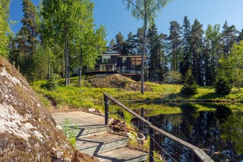 a house on a hill next to a body of water at Stay North - Mustikka in Lohja