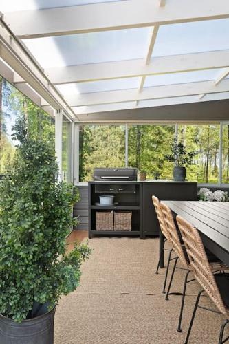 a patio with a wooden table and chairs and a table at Stay North - Mustikka in Lohja
