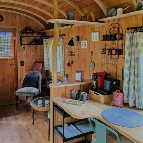 a kitchen with a table and chairs in a cabin at Roulotte Ravel-Emoi Chambre Insolite de Charme in Ramillies