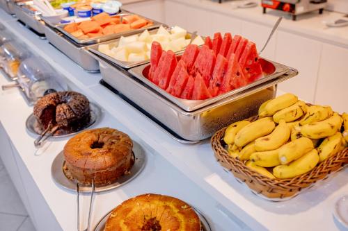 a buffet filled with different types of fruits and pastries at Hotel San Gabriel in Sao Paulo