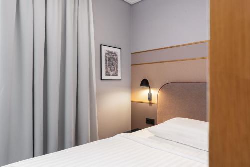 a hotel room with a bed and a curtain at Fonnental Design Hotel Tallinn in Tallinn