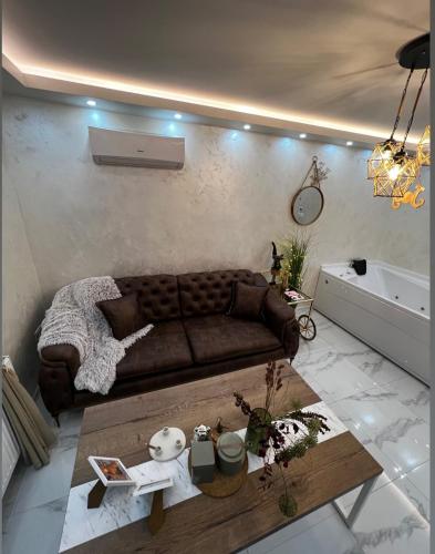 a living room with a brown couch and a table at Teddy Bear Jacuzzi Spa Apartment Sarajevo in Sarajevo