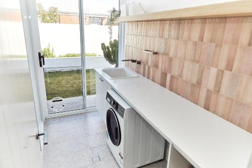 a kitchen with a washer and dryer under a counter at The Elanora in Dunsborough