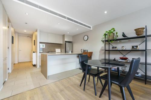 a kitchen and dining room with a table and chairs at Elegant Apartment in Kingston Foreshore - Hosted by Canstay in Kingston