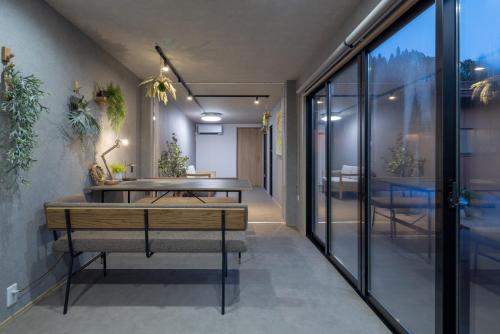 a dining room with a table and some plants at Riverside Sauna Base Conpeki in Taniai