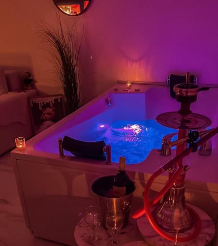 a purple room with a tub with a bottle of wine at Teddy Bear Jacuzzi Spa Apartment Sarajevo in Sarajevo
