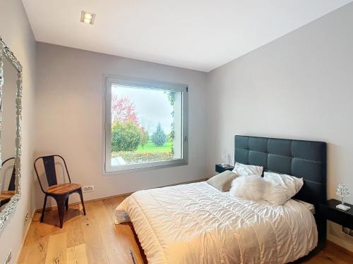 a bedroom with a large bed and a window at Maison du Golf in Publier