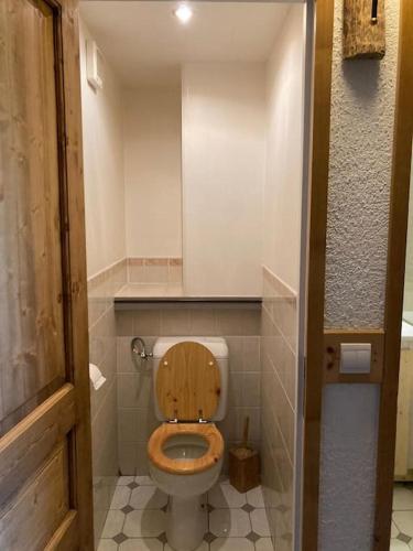 La salle de bains est pourvue de toilettes et d'un siège en bois. dans l'établissement SLA201 - Très spacieux apt 2pièces 4pers, à Tignes
