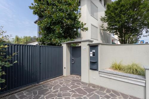a house with a black gate and a stone driveway at palazzo mazzini in Cornaredo