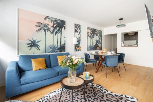 un salon avec un canapé bleu et une table dans l'établissement SERENERS - Charming Serviced Apartments - Beaugrenelle, à Paris