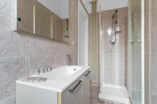 un bagno bianco con lavandino e doccia di SA7 - Porta Venezia - Duomo - Large Apartment - a Milano