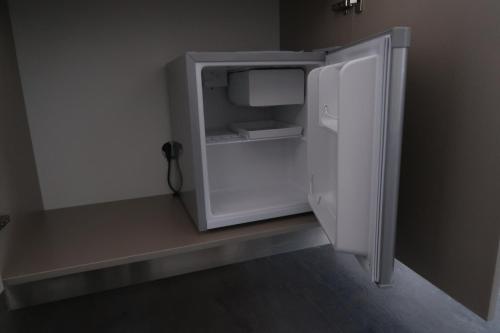 a white refrigerator with its door open in a room at LUXUS Hostel Rabe in Mühlhausen