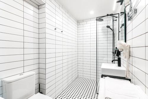 a white bathroom with black and white tiles at Fonnental Design Hotel Tallinn in Tallinn