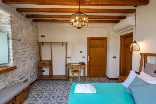 a bedroom with a green bed and a table at Nostos Country House in Tsagarada
